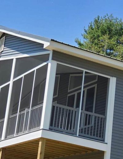 screened in porch on the second story of a gray house